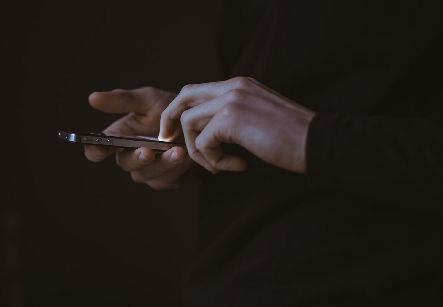 silhouette photo of person holding smartphone